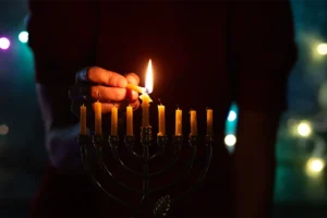 Menorah candle being lit.