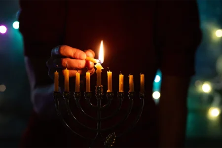 Menorah candle being lit.