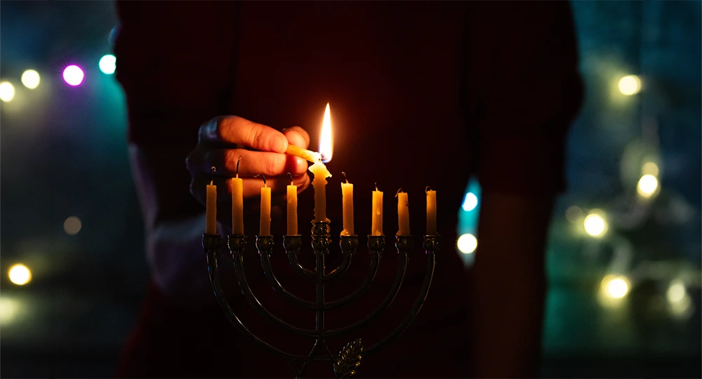Menorah candle being lit.
